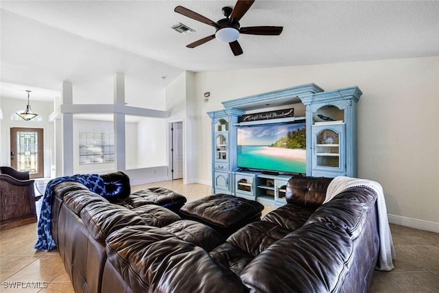 living room featuring ceiling fan, light tile patterned flooring, lofted ceiling, and a textured ceiling