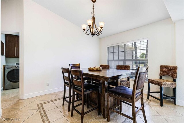 dining area featuring light tile patterned floors, washer / clothes dryer, and an inviting chandelier