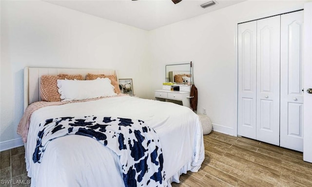 bedroom with ceiling fan, a closet, and dark wood-type flooring