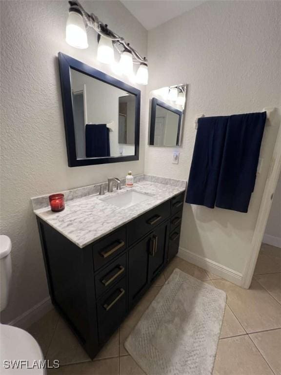 bathroom featuring tile patterned flooring, vanity, and toilet