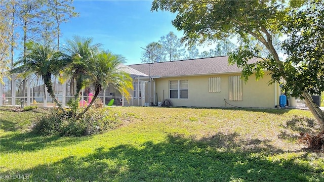 rear view of house featuring a yard and a lanai