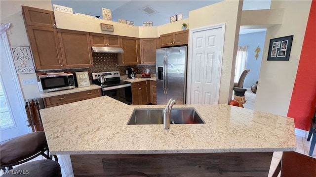 kitchen featuring stainless steel appliances, tasteful backsplash, a breakfast bar, and sink