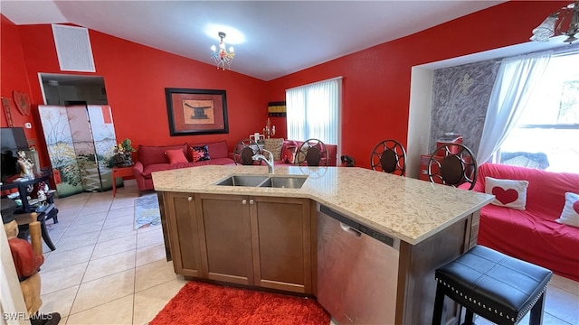 kitchen featuring vaulted ceiling, light tile patterned flooring, dishwasher, sink, and a center island with sink