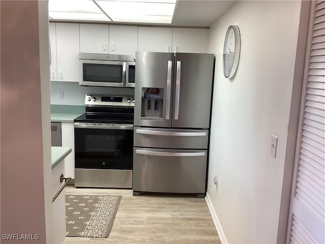 kitchen featuring light wood-type flooring, stainless steel appliances, and white cabinetry