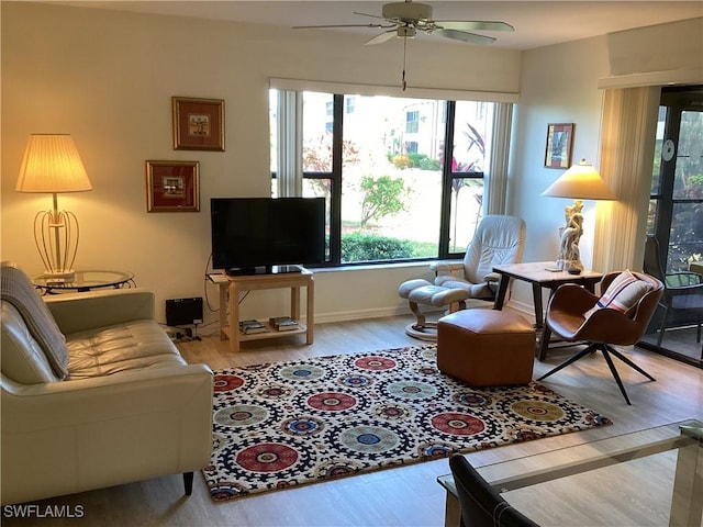 living room with plenty of natural light, ceiling fan, and light hardwood / wood-style flooring