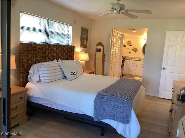 bedroom with ensuite bath, ceiling fan, a closet, and wood-type flooring