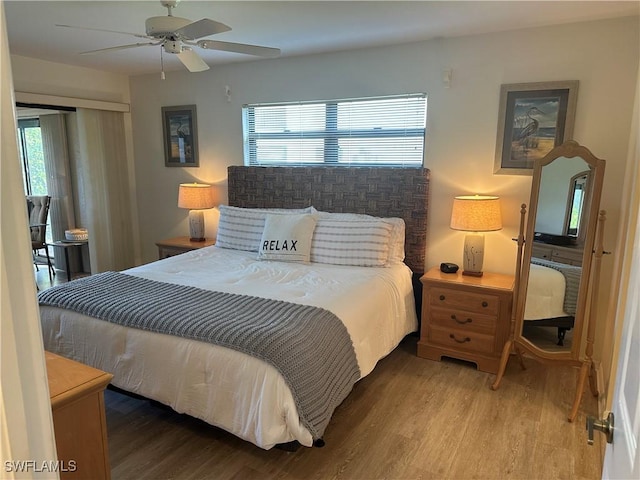 bedroom with hardwood / wood-style floors, ceiling fan, and multiple windows