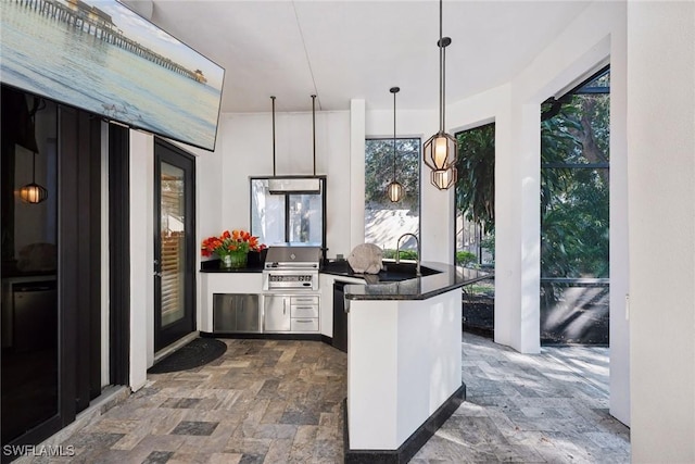 kitchen with kitchen peninsula, a wealth of natural light, and decorative light fixtures