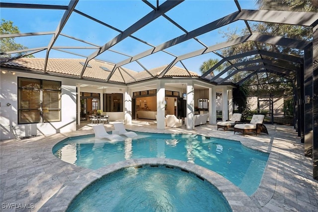 view of pool featuring ceiling fan, an in ground hot tub, a patio, and glass enclosure