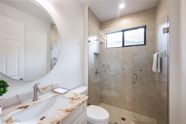 bathroom with vanity, toilet, and a shower with door