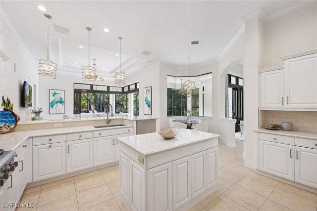 kitchen with pendant lighting, light tile patterned floors, white cabinetry, and sink