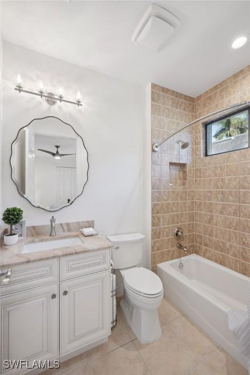 full bathroom featuring tile patterned floors, tiled shower / bath combo, toilet, and vanity