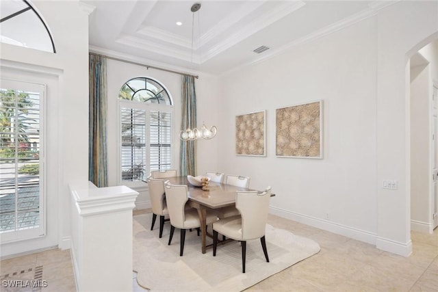 tiled dining space with a raised ceiling, a wealth of natural light, and crown molding