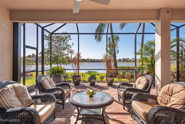 sunroom / solarium featuring ceiling fan and a water view