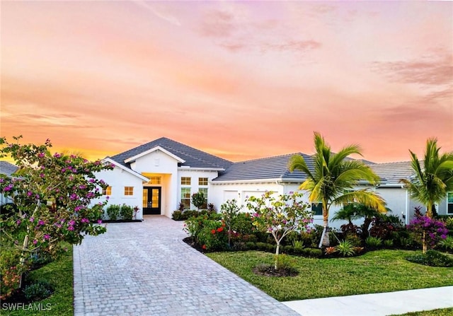 view of front of property featuring french doors and a yard