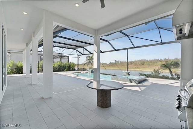 outdoor pool with a patio, a water view, glass enclosure, and a ceiling fan