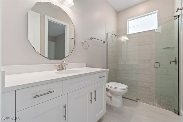 bathroom with vanity, an enclosed shower, and toilet