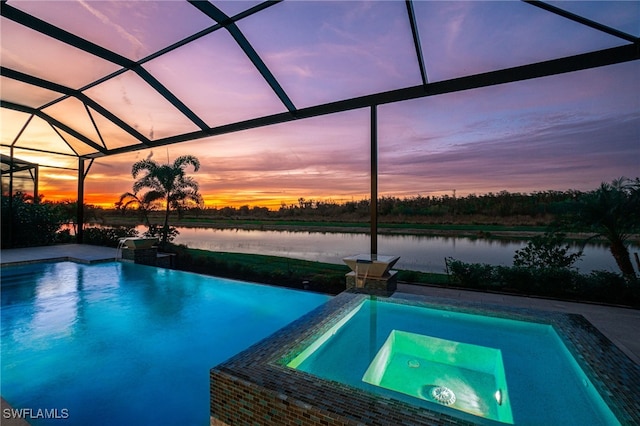 view of pool with a patio area, a water view, a lanai, and a pool with connected hot tub