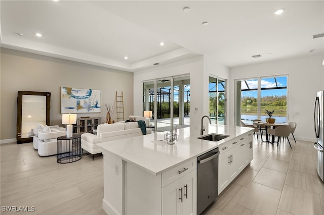 kitchen featuring a sink, open floor plan, light countertops, dishwasher, and a raised ceiling