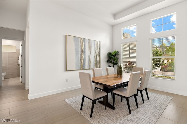 dining area with a high ceiling and baseboards