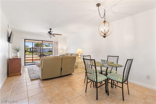 dining area featuring light tile patterned floors and ceiling fan with notable chandelier