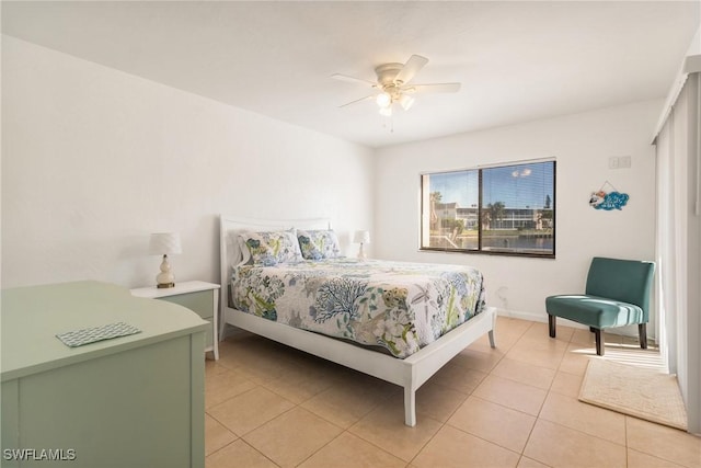 tiled bedroom featuring ceiling fan