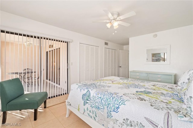 bedroom with multiple closets, ceiling fan, and tile patterned flooring