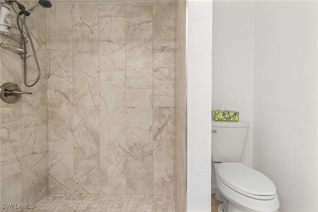 bathroom featuring toilet and tiled shower