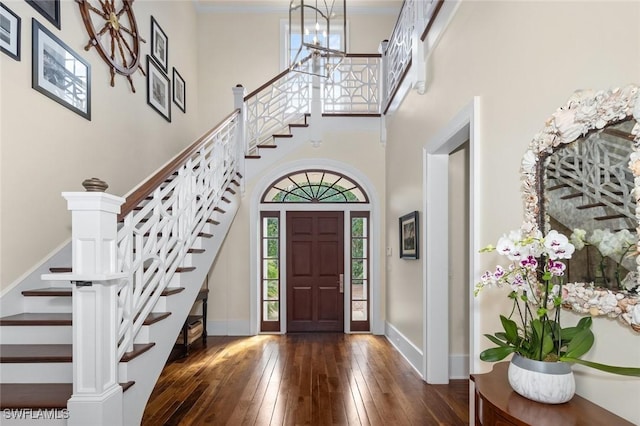 entryway featuring dark hardwood / wood-style flooring and a towering ceiling