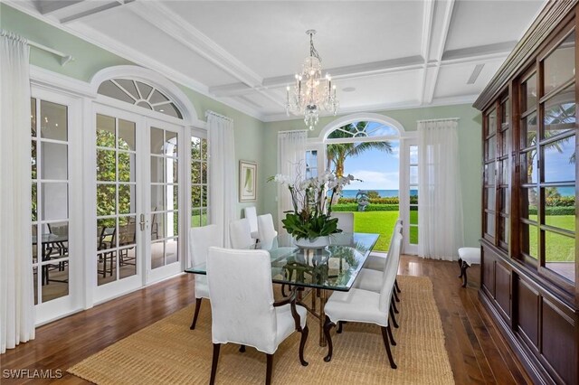 sunroom / solarium featuring dark hardwood / wood-style flooring, an inviting chandelier, french doors, and coffered ceiling