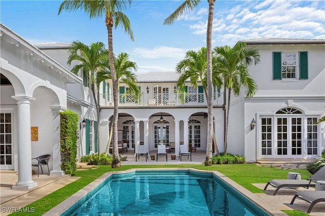 back of house with ceiling fan, a patio area, french doors, and a balcony