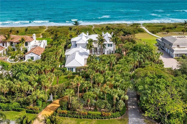 birds eye view of property with a water view and a beach view