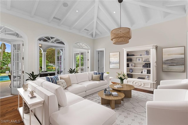 living room with light wood-type flooring, high vaulted ceiling, beamed ceiling, and french doors