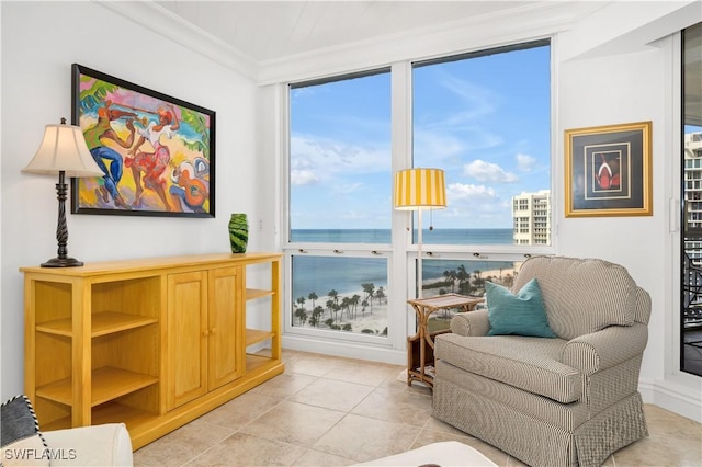 living area with a water view, ornamental molding, and light tile patterned floors