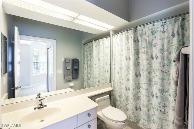 bathroom with vanity, curtained shower, and toilet