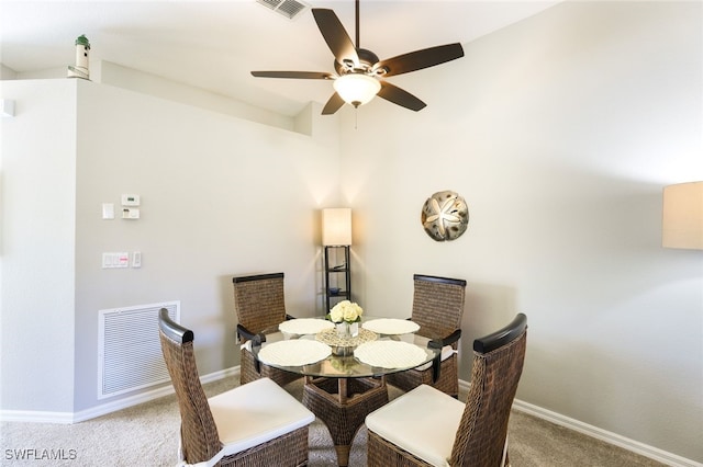 carpeted dining room with ceiling fan