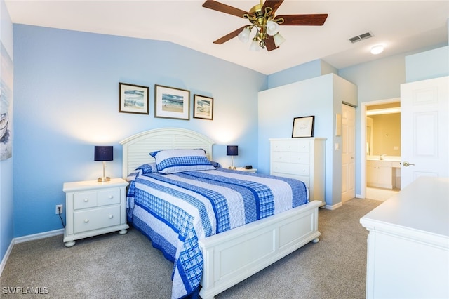 carpeted bedroom with connected bathroom, ceiling fan, and vaulted ceiling