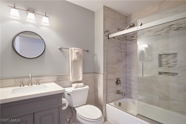 full bathroom with vanity, bath / shower combo with glass door, and toilet