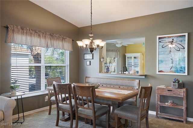 carpeted dining room with ceiling fan with notable chandelier