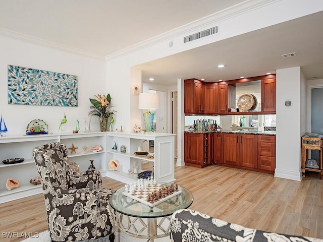 living room with light hardwood / wood-style floors and ornamental molding