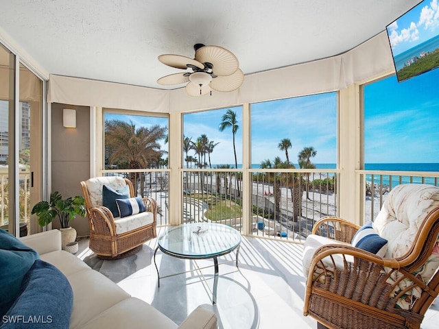 sunroom / solarium featuring ceiling fan, a water view, and a wealth of natural light