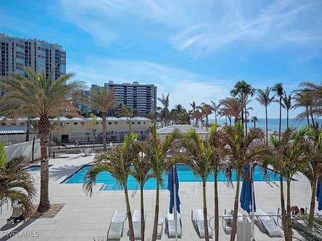 view of pool with a water view and a patio