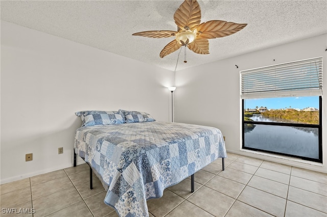 tiled bedroom featuring a textured ceiling and ceiling fan