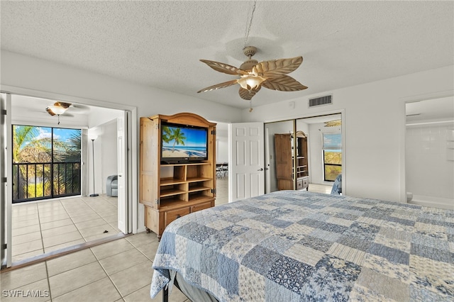 bedroom with access to exterior, a textured ceiling, ceiling fan, light tile patterned floors, and a closet