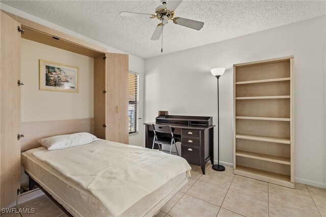 tiled bedroom featuring a textured ceiling and ceiling fan