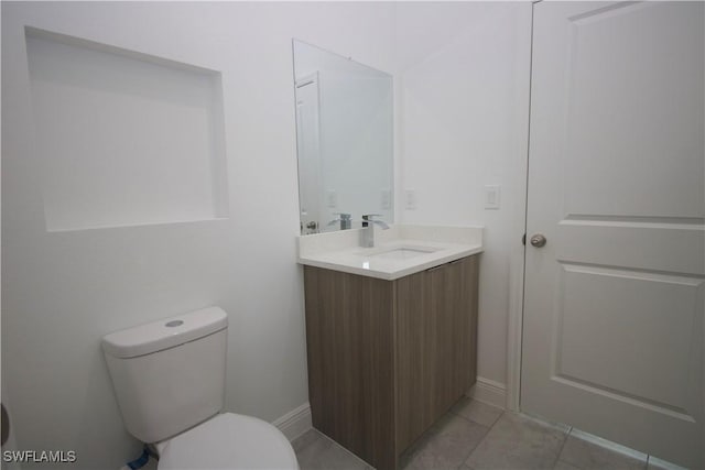 bathroom featuring tile patterned floors, vanity, and toilet