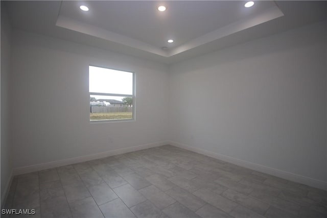 spare room with a tray ceiling