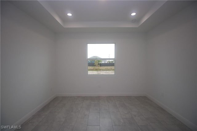 unfurnished room with hardwood / wood-style floors and a tray ceiling