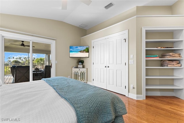 bedroom featuring access to outside, vaulted ceiling, hardwood / wood-style flooring, ceiling fan, and a closet