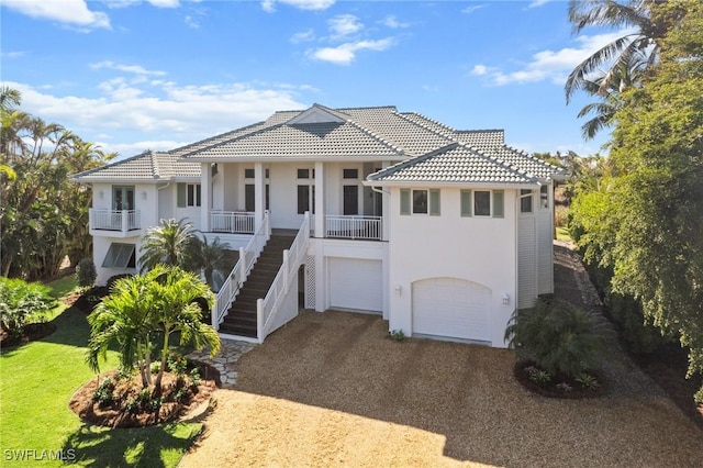 mediterranean / spanish home featuring covered porch and a garage